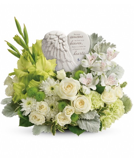 Keepsake sculpture surrounded by green and white blooms.