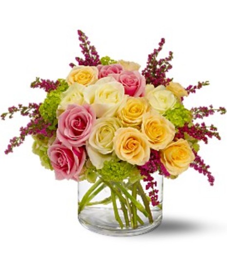 Pink, peach and white flowers in a clear glass vase.