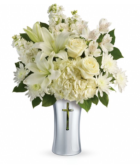 White hydrangea and lilies in a ceramic vase with a cross cut-out.