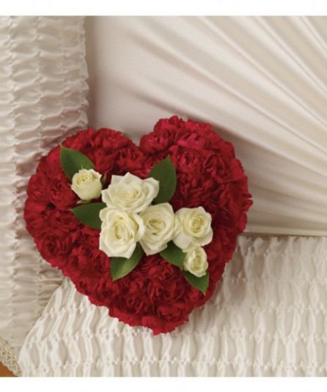 Casket insert in the shape of a red heart with white rose accents.